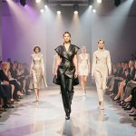 Défilé de mode contemporain à Paris avec des mannequins et des invités élégants dans une ambiance créative éclairée par des projecteurs.
